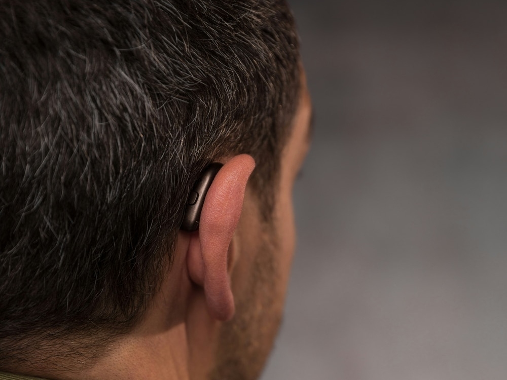 Doctor of Audiology programming a new hearing aid during a fitting appointment at Physicians Hearing Clinic in Sarasota, FL